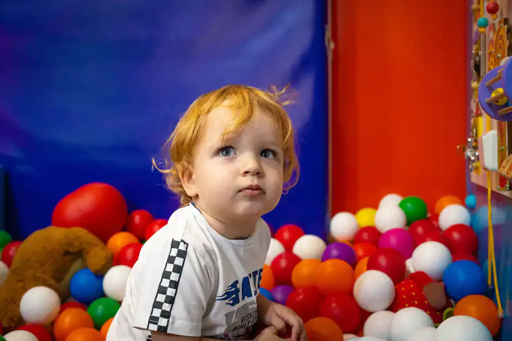 Toddlers exploring a safe, padded soft play area